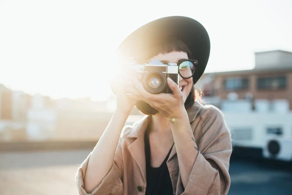 Portrait of person taking a picture with a camera