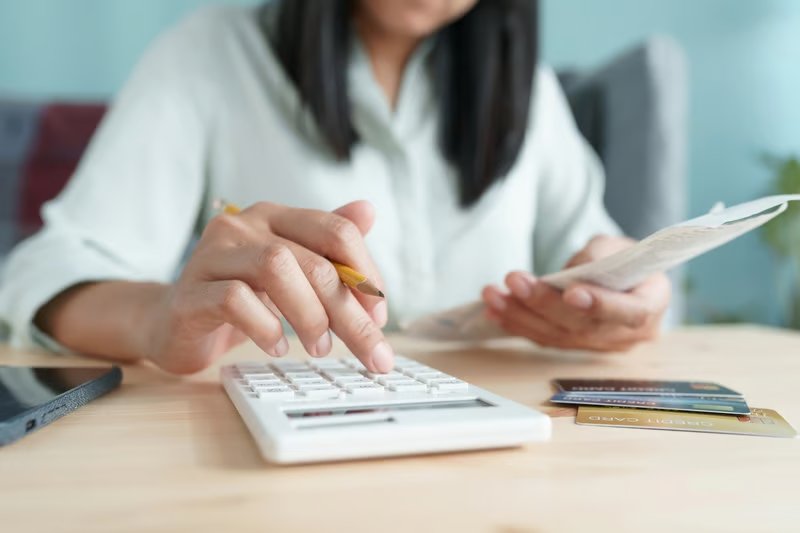 Calculating Student Loan Payments Hand of Asian woman are calculating costs and payments. Source: The College Investor